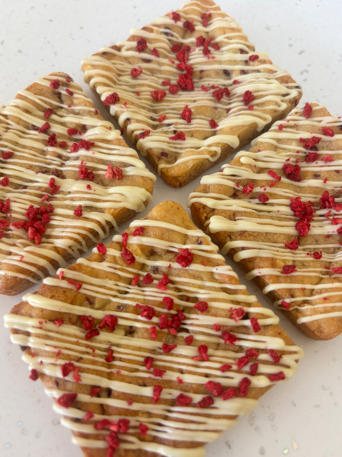 White chocolate and raspberry cookies drizzled with white chocolate and topped with freeze dried raspberries