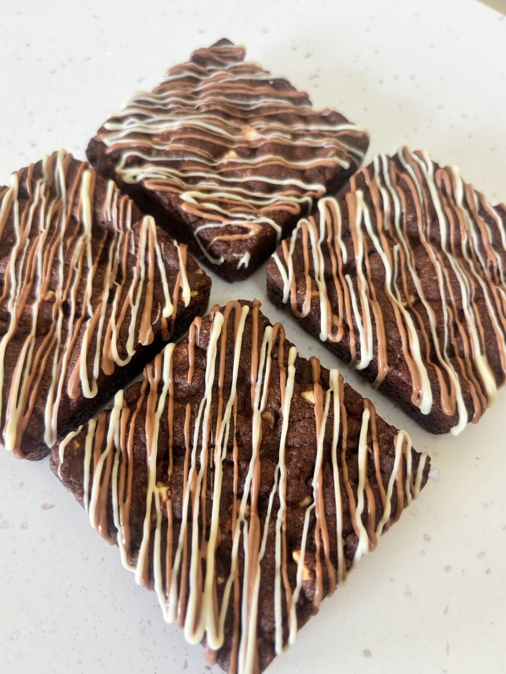 Triple chocolate cookie packed with white, milk and dark chocolate, finished with a milk and white chocolate drizzle